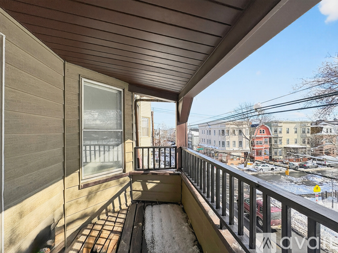 A balcony with a view of a parking lot and buildings.