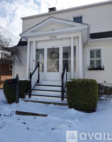 A white house with the number 1230 on the front door.