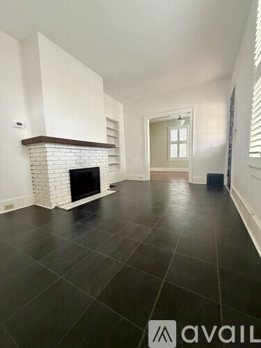 A living room with a fireplace and black tile flooring.