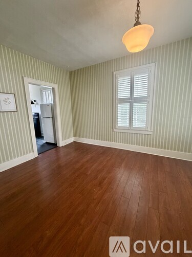 A room with wooden floors and a striped wallpaper.