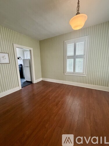A room with wooden floors and a striped wallpaper.