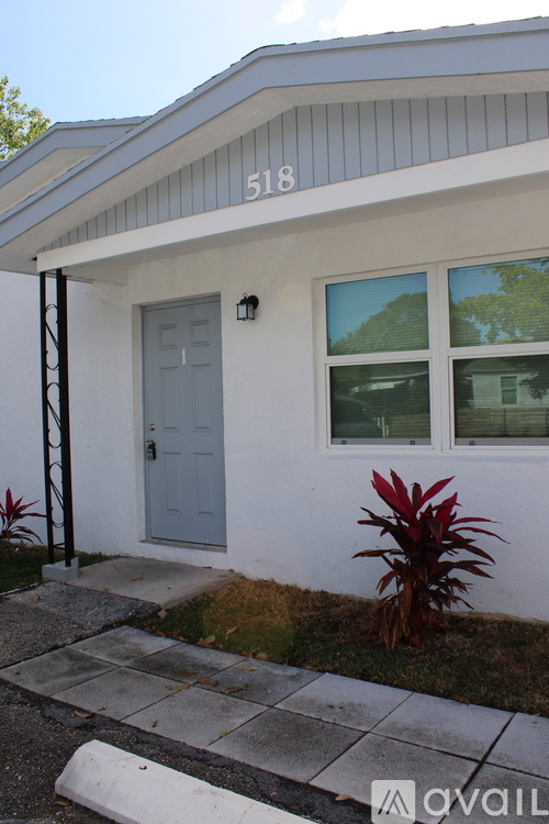 A house numbered 518 with a grey door and a small porch.