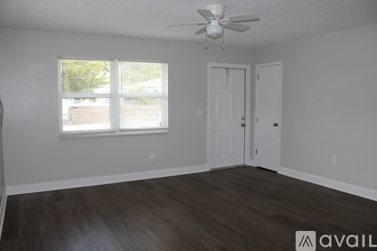 A room with a ceiling fan and two doors.