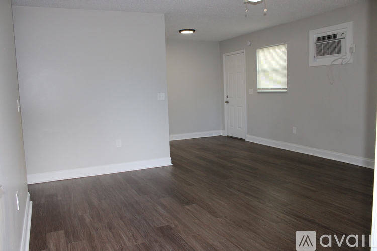 A room with wooden flooring and white walls.