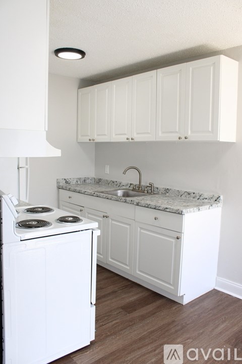 A kitchen with white appliances and cabinets.