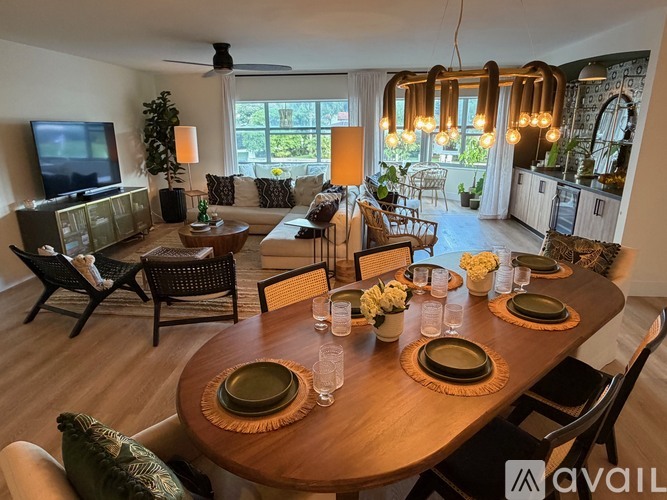 A modern dining room with a wooden table set for a meal.