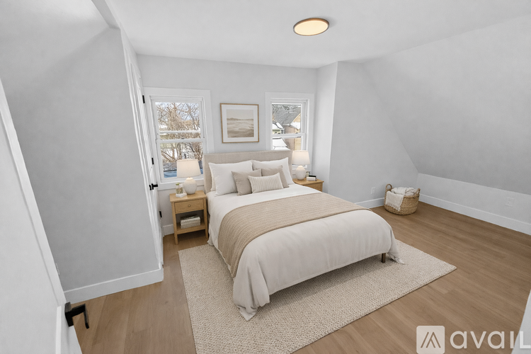 A bedroom with a large bed and a window overlooking a snowy landscape.