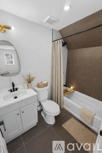 A bathroom with a white toilet, sink, and bathtub.