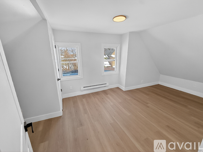 A room with wooden flooring and a window showing a snowy landscape outside.