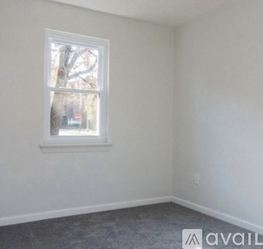 A room with a window and a car parked outside.