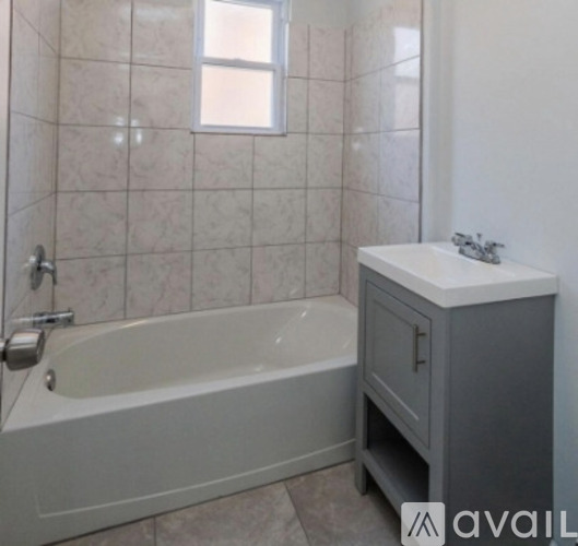 A white bathroom with a tub and a sink.