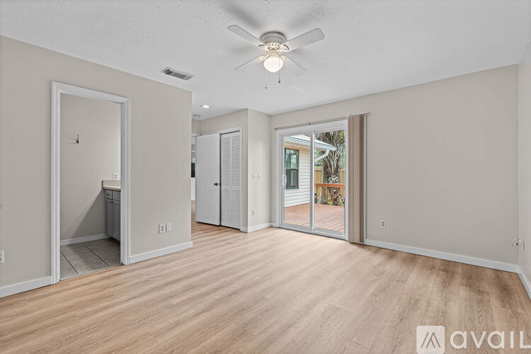 A spacious room with a ceiling fan and sliding glass doors.