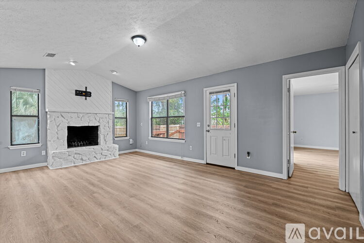 A spacious living room with a fireplace and hardwood floors.