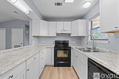 A kitchen with a black oven and white cabinets.