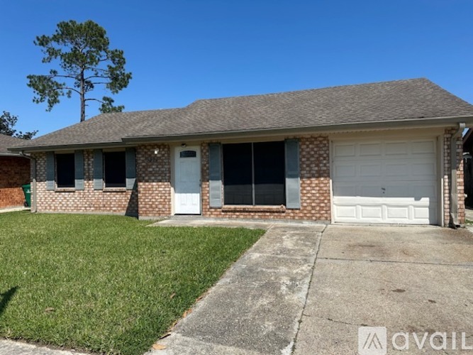 A house with a white garage door and a brick facade.
