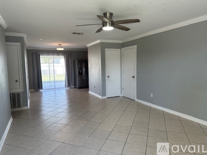 A spacious room with a ceiling fan and tile flooring.