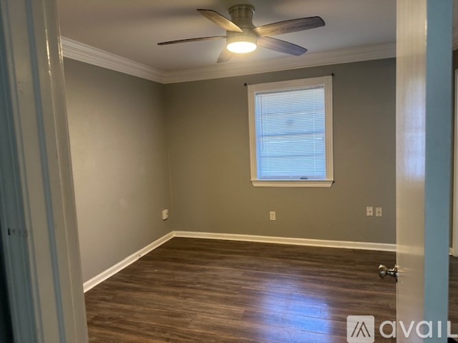 A room with a ceiling fan and a window.