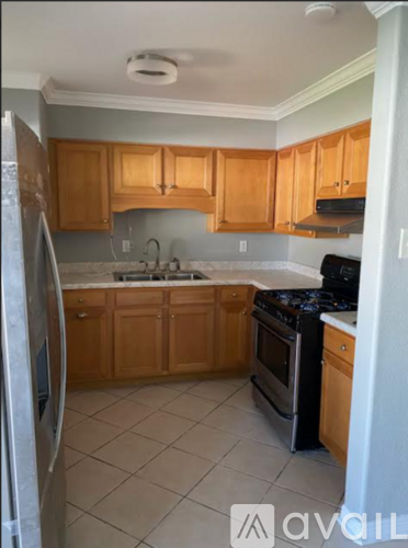 A kitchen with wooden cabinets and a stainless steel refrigerator.