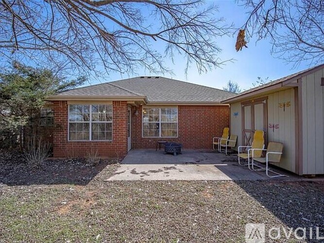 A house with a red brick exterior and a grey roof is for sale.