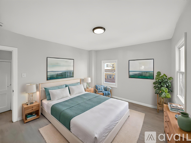 A bedroom with a large bed and a green plant.
