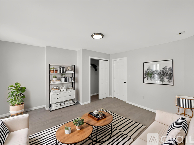 A living room with a white sofa, a wooden coffee table, and a striped rug.