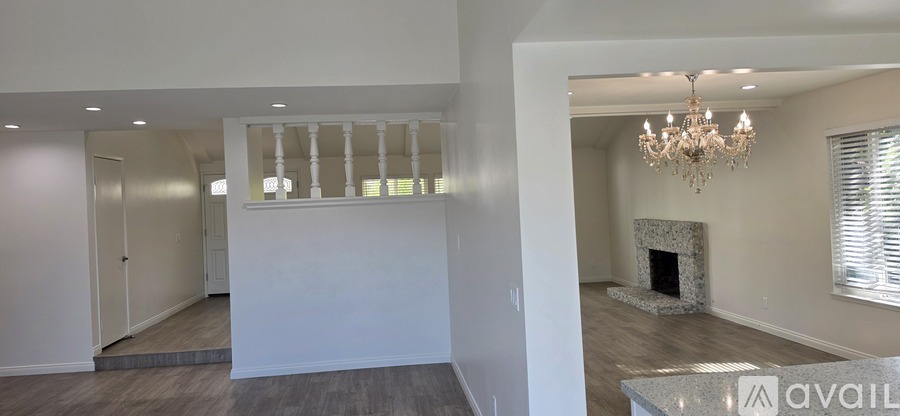 A living room with a fireplace and a chandelier.
