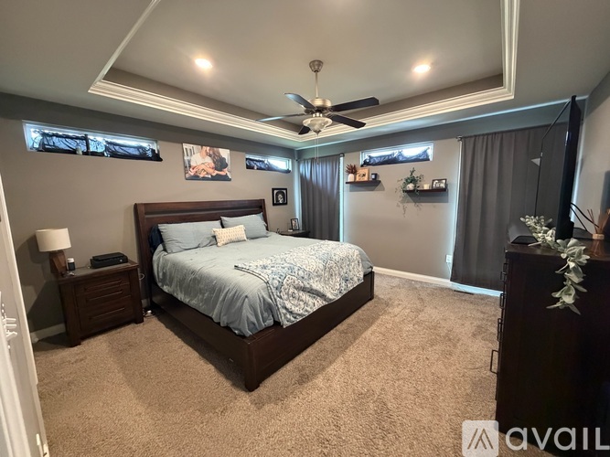 A bedroom with a large bed and a ceiling fan.