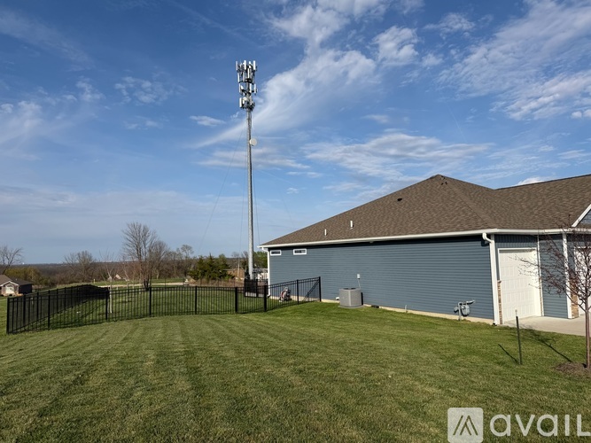 A grassy field with a light pole and a building in the background.