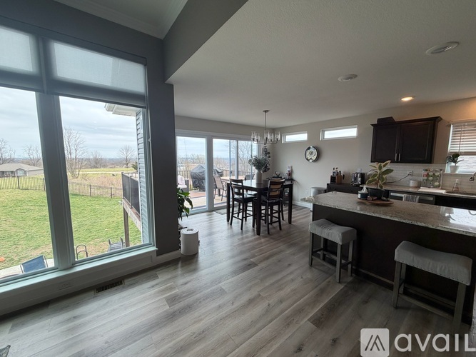A kitchen with a large island and a dining table with chairs.