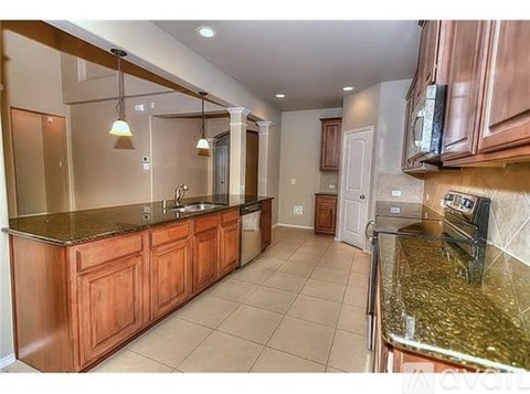 A kitchen with wooden cabinets and a granite countertop.