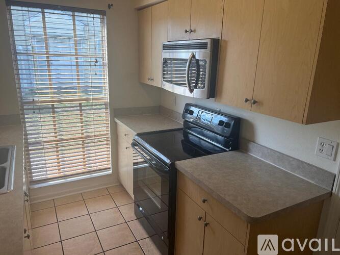 A kitchen with wooden cabinets and a black oven.