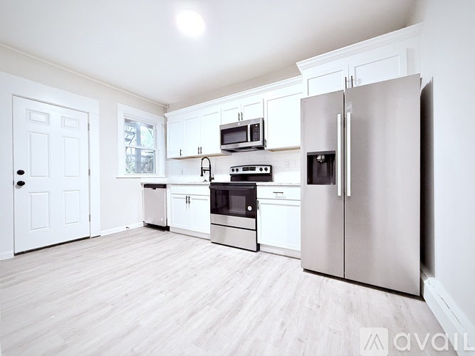 A kitchen with white cabinets and appliances.