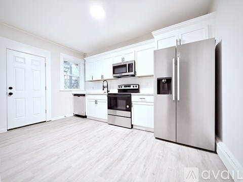 A kitchen with white cabinets and appliances.