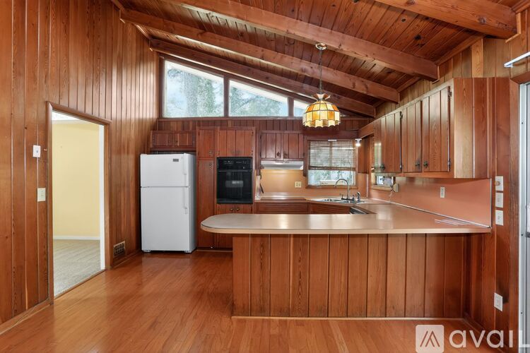 A kitchen with wooden cabinets and a white refrigerator.