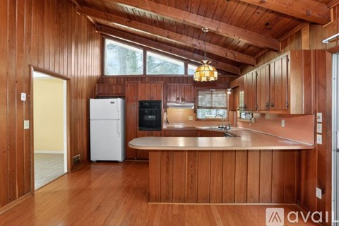 A kitchen with wooden cabinets and a white refrigerator.