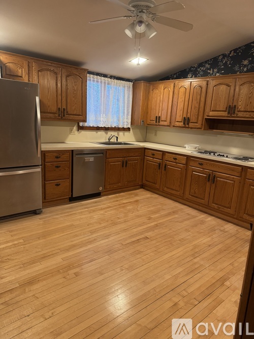 A kitchen with wooden cabinets and a refrigerator.