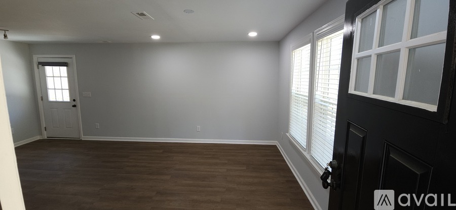 A room with a door and a window with blinds.
