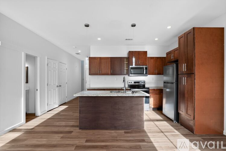 A modern kitchen with brown cabinets and a white island.