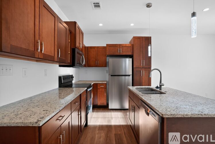 A kitchen with wooden cabinets and granite countertops.