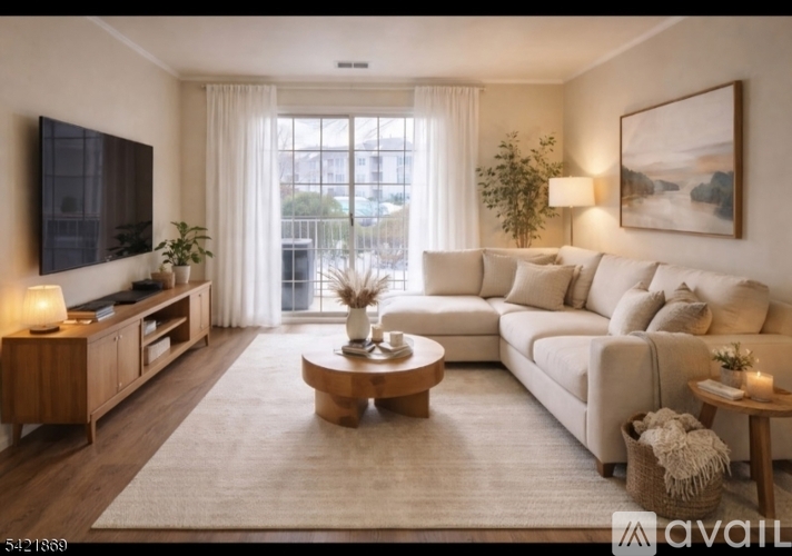 A modern living room with a large couch, a coffee table, and a flat-screen TV.