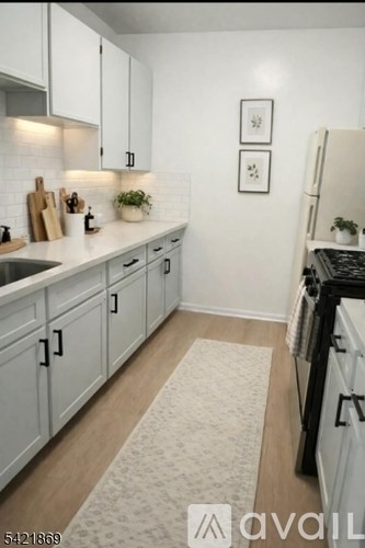 A kitchen with white cabinets and a black stove top oven.