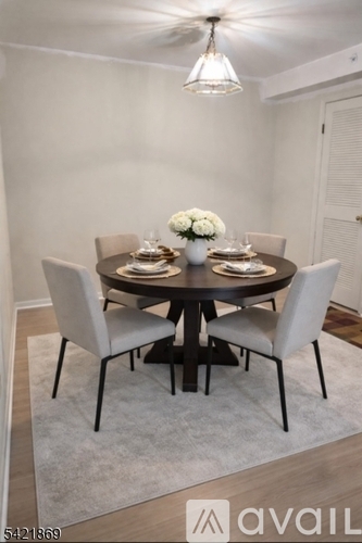 A dining room with a round table and chairs.