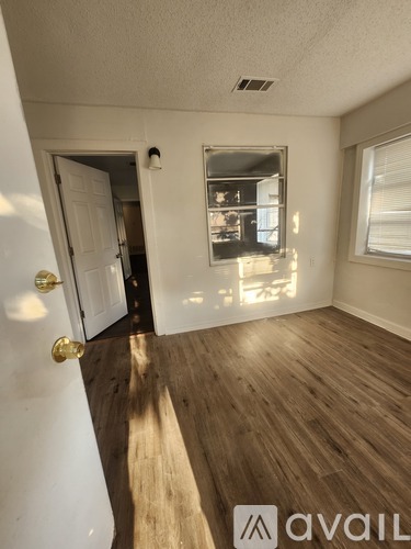 A room with wooden floors and a white door.