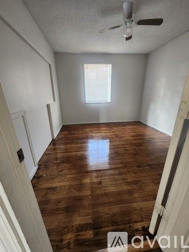 A room with wooden flooring and a window letting in light.