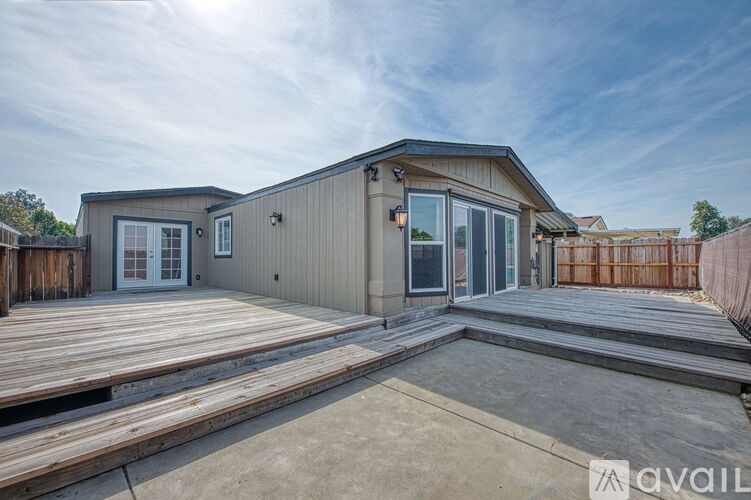 A house with a deck and a fence in the background.
