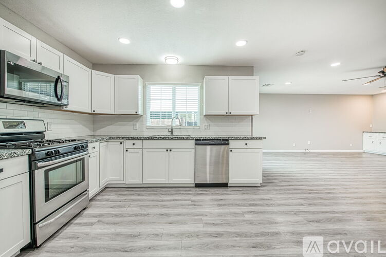 A kitchen with white cabinets and a black stove top oven.