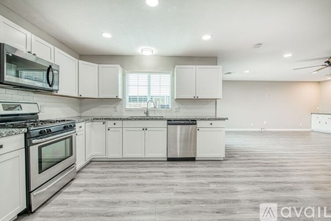 A kitchen with white cabinets and a black stove top oven.