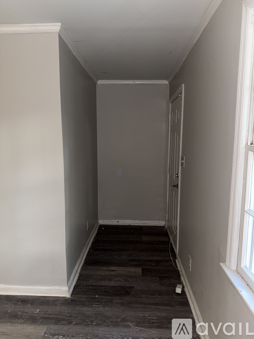 A long, narrow hallway with a door at the end.