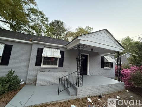 A house with a grey brick exterior and a black door.