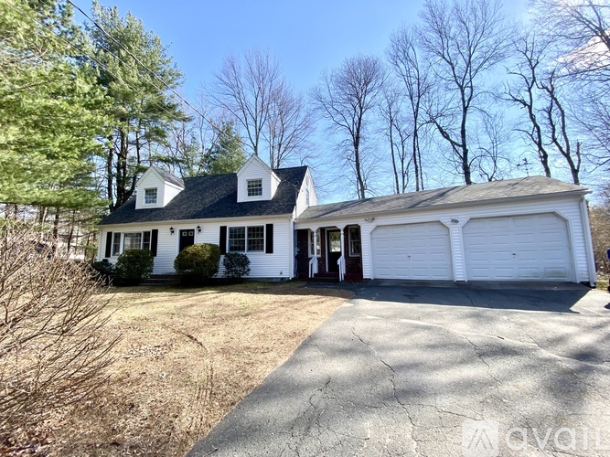 A white house with a black roof and a garage door.